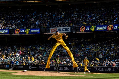 A pitcher throws on stilts during a Savannah Bananas baseball game against the Party Animals at Yankee Stadium in April.