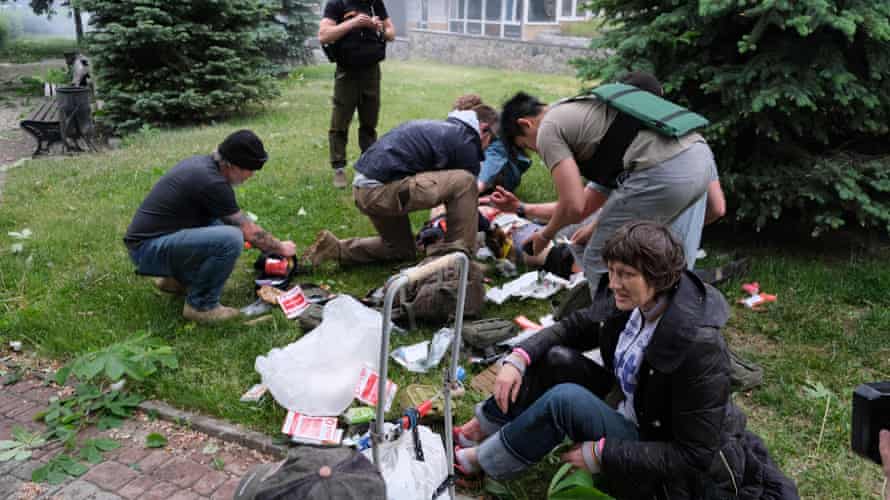 Residents provide medical care to a man wounded as a result of shelling in the city.