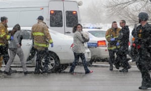 People are escorted away from the scene by police after a gunman opened fire at a Planned Parenthood facility on Friday.