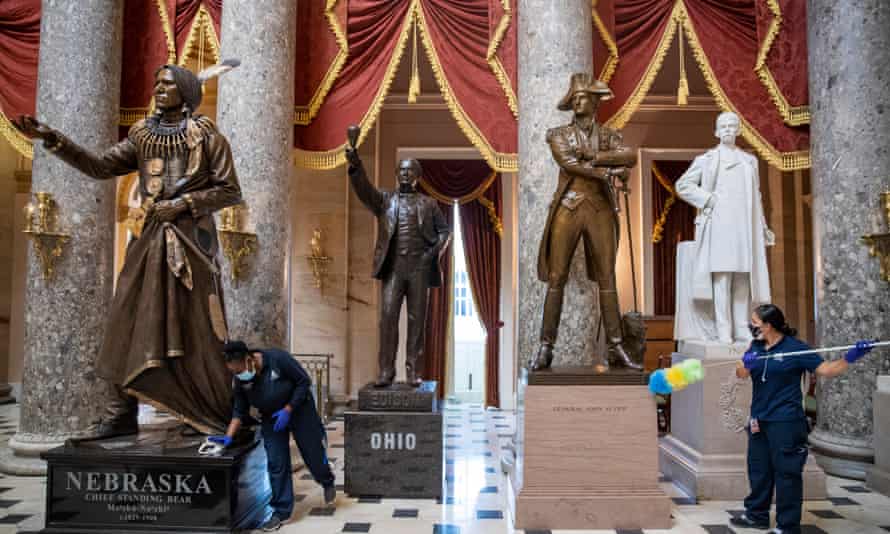 A cleaning crew dusts residue from the pedestals of the statues in Statuary Hall inside the US Capitol in Washington.