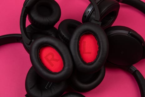 a selection of headphones photographed together on a magenta background