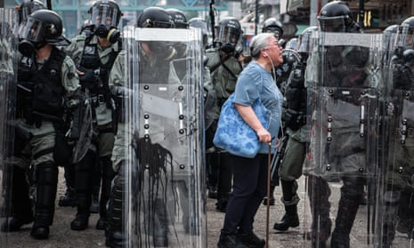 A woman shouts at police officers during protests in Hong Kong in 2019.
