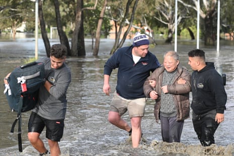 A man is helped through flood waters in Maribyrnong in Melbourne on Friday.