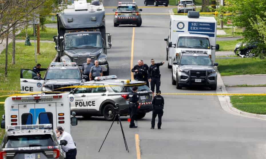 Police officers work at the scene where police shot a suspect who was walking down a city street carrying a gun, as four nearby schools were placed on lockdown, in Toronto.
