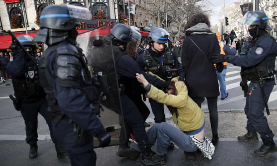 A striking worker is grabbed by police outside Gare de Lyon in Paris, France