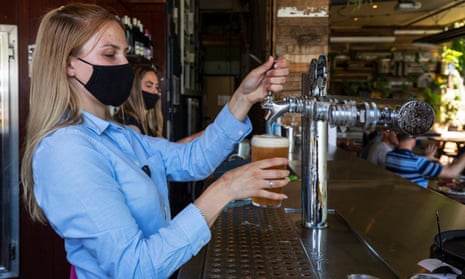 Bar staff are seen pulling a beer at College Lawn Hotel in Prahran on October 28, 2020 in Melbourne, Australia. (Photo by Daniel Pockett/Getty Images)