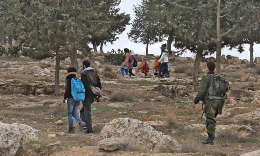 Israeli volunteers Maya Eshel and Itai Feitelson escort Palestinian children home from school near the illegal settlement of Havat Ma’on.
