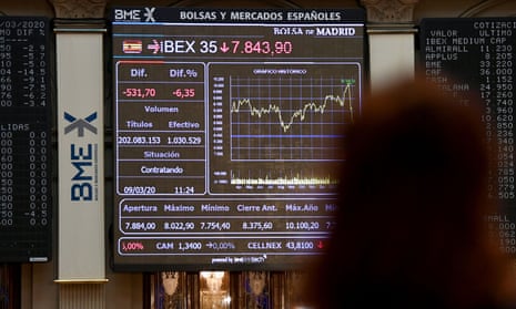A woman looks at a screen showing the Ibex 35 stock market index at Spain’s stock exchange in Madrid