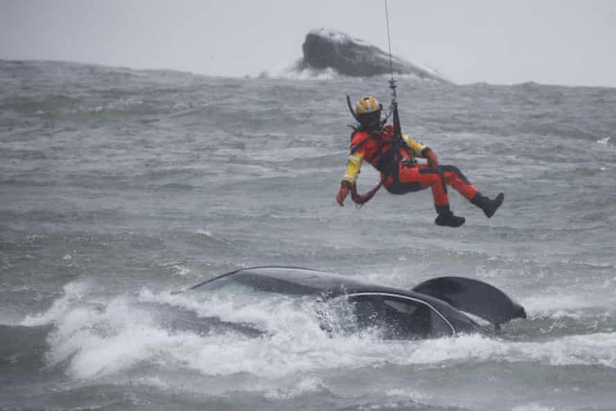 Ein Taucher der Küstenwache wird von einem Hubschrauber herabgelassen, um eine Leiche aus dem Fahrzeug zu ziehen, das in der Nähe des Randes der American Falls feststeckt.