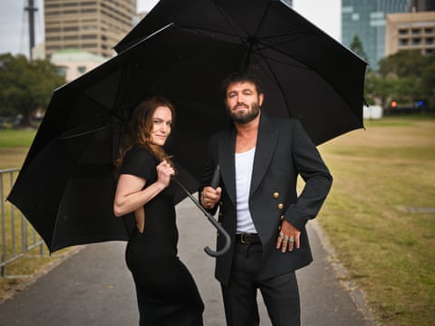 Angus and Julia Stone walk with umbrellas in the Domain in Sydney, Australia