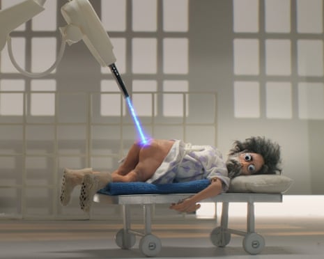 A puppet is shown lying on a hospital trolley with a laser beaming onto his bare backside in a scene from André Is an Idiot.