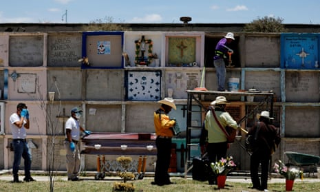 Funeral workers stand by the coffin of a woman who died of coronavirus , as musicians stand next to them at the Municipal cemetery in Nezahualcoyotl, State of Mexico, Mexico 12 June, 2020.