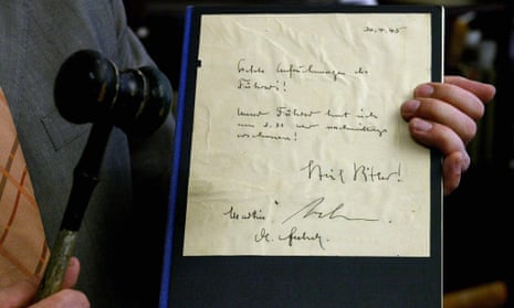 A German auctioneer holding one of the last circulating copies of the fake Hitler diaries, which went under the hammer in 2004. 