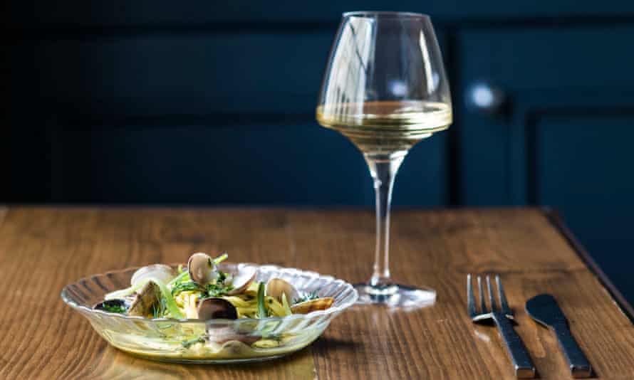 Plate of seafood and a glass of white wine on a table at Plateau, Brighton