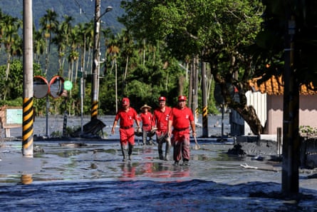 Emergency workers wade through water.