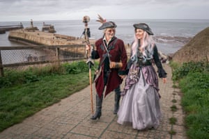 A goth couple walk along a coastal path