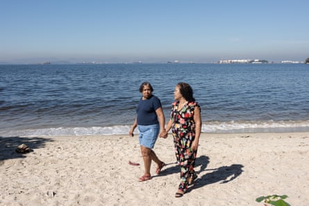 two women walk on a beach