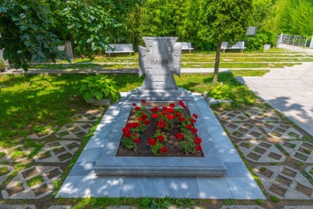 Red flowers growing on a well-maintained grave