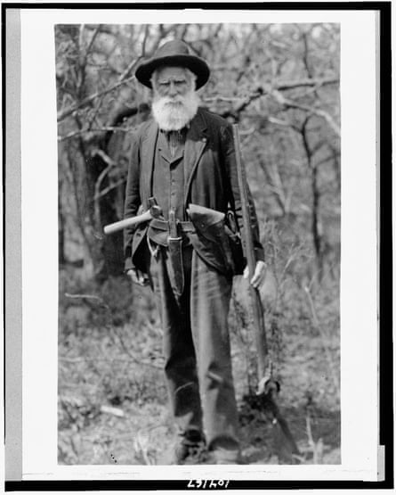 black and white photo of man holding a gun