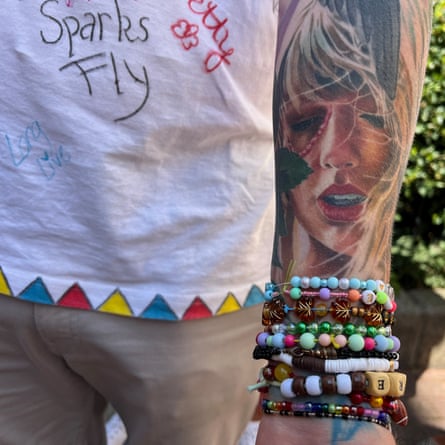A Taylor Swift fan shows a tattoo of the singer on their forearm