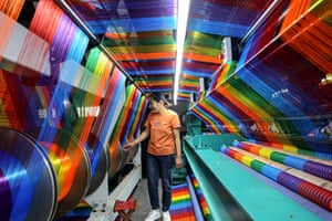 Employee walking past colourful array of threads and spools