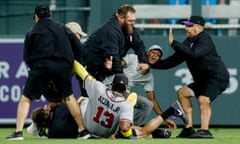 Ronald Acuña Jr (13) falls to the ground as security guards tackles two fans