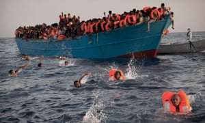 Eritrean migrants jump into the water during a rescue operation near the Libyan coast in August 2016.