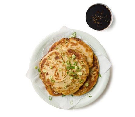 Felicity Cloake’s Taiwanese scallion or spring onion pancake 11. Starting with the first pancake, flatten it slightly, then roll it out into a thin disc. Set a nonstick or well-seasoned frying pan over a medium heat, and just cover the base with oil. Once it’s very hot, add the pancake, then cover the pan and turn down the heat to medium-low. Leave to cook for about three minutes, until golden underneath, then turn over and repeat. Uncover, continue to cook until the pancake is browned to your liking, then drain on kitchen paper and repeat with the remaining pancakes, adding more oil as required. Cut the pancakes into wedges (if serving as a snack) and serve with the sauce alongside for dipping.