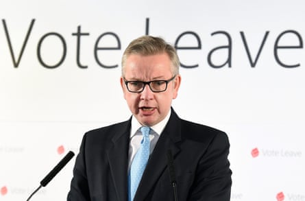 A man in a dark suit and tie with the words ‘Vote Leave’ on a wall behind him.