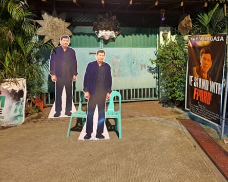 Cardboard cutouts of the former president stand outside his home in Davao.