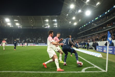 Ihlas Bebou of Hoffenheim is challenged by Jonas Hofmann and Robert Andrich of Bayer Leverkusen.