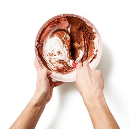 Ajouter le cacao et la plupart des pépites de chocolat, puis incorporer jusqu'à ce qu'ils soient bien mélangés et en prenant soin de ne pas trop faire sortir l'air.