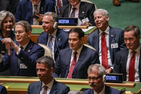 people in suits sit in rows