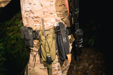 Close up of man belt with flash light and large black rifle