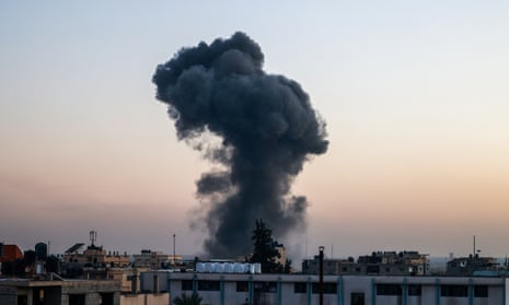 A billow of smoke rises over buildings after an Israeli strike in Rafah, southern Gaza.