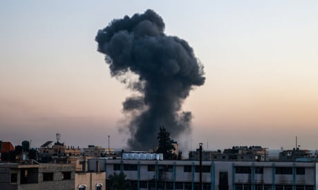 A billow of smoke rises over buildings after an Israeli strike in Rafah, southern Gaza Strip.