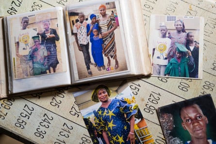 A family photo album with photographs scattered around it.