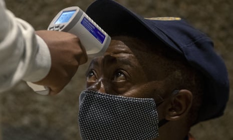 A police officer has his temperature taken as part of a mass screening campaign in Johannesburg, South Africa