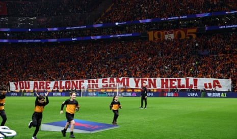 Galatasaray fans display a banner in the stands as young mascots run on the pitch before the match.
