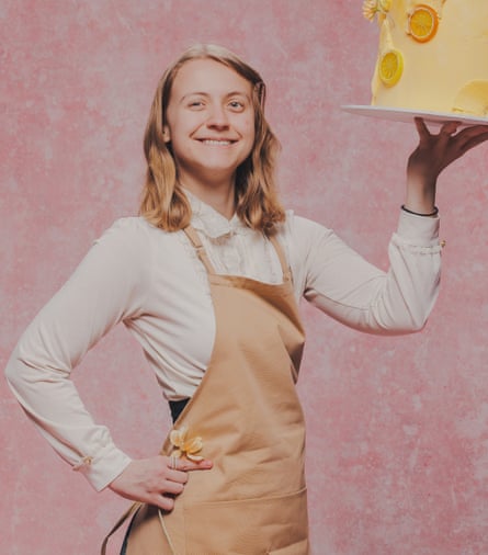 A young person holds up a yellow cake.