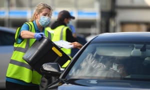 Workers collect completed Covid-19 tests at a drive-in testing centre in Bolton.
