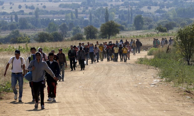 Migrants walk from the Macedonian border into Serbia