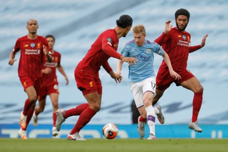 Kevin De Bruyne surges past Joe Gomez as his Liverpool teammates look on during their July 2020 Premier League match at the Etihad Stadium.
