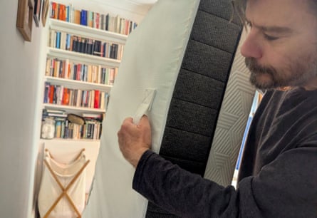 A man moves the Panda Hybrid Bamboo Mattress on its side using the handles