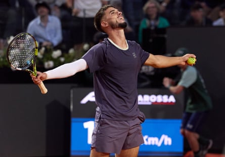 Dino Prizmic waves his arms after defeating Novak Djokovic