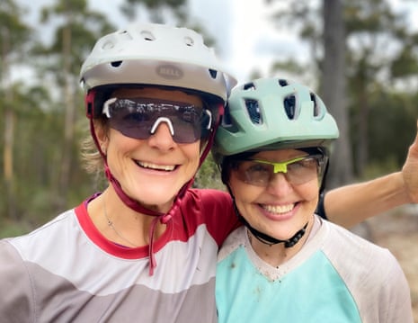 Two mountain bikers in bicycle helmets and sunglasses smiling