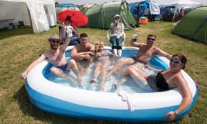 revellers toast the warm weather in a paddling pool at Glastonbury festival