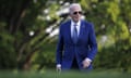 Biden in suit and shades strolling in on a lawn.