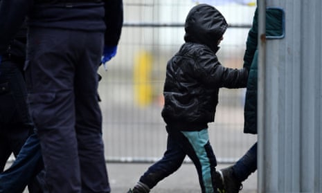 A UK immigration enforcement officer escorts a child migrant on arrival in Dover in January 2023.