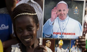 A woman waits for Pope Francis's arrival in Kampala. 'Four in every 10 of the 35 million Ugandans are Catholics. The pope is coming to a country where, unlike in the west, his flock is growing.'